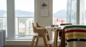 Cleaning a space-saving high chair featuring a removable, dishwasher-safe tray and wipeable fabric.
