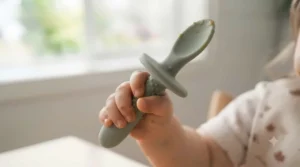 Close-up of a safety choke guard on an infant training spoon, a key feature to look for in the best baby utensils.