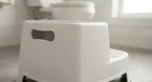 A portable plastic step stool for potty training equipped with side cut-out handles for easy moving.